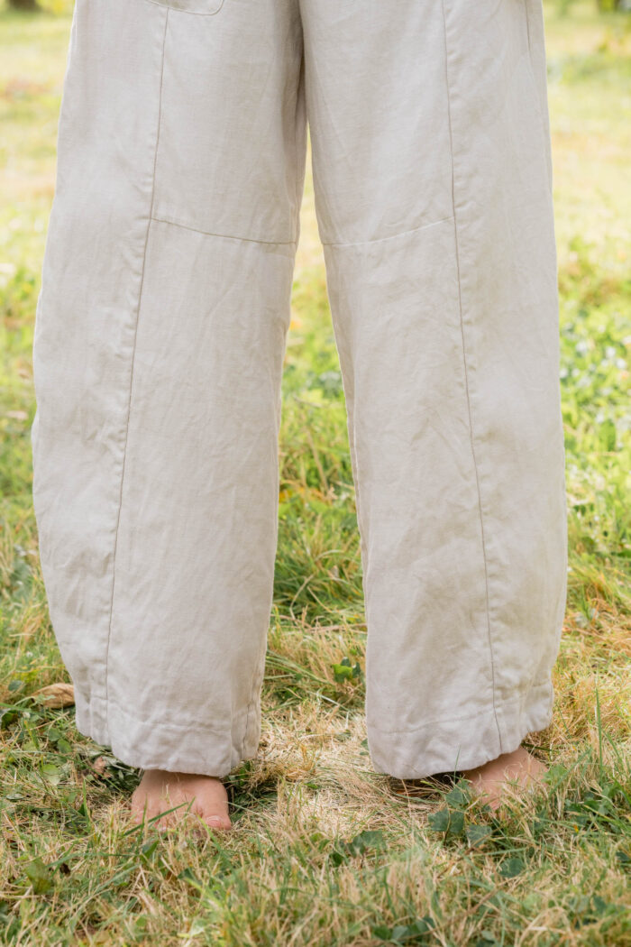 model wearing tailored line pants sula linen barrel leg trousers and apron blouse