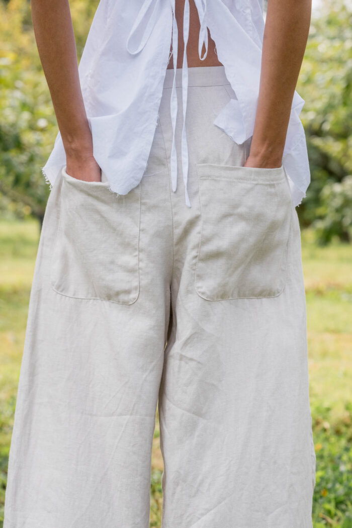 model wearing tailored line pants sula linen barrel leg trousers and apron blouse