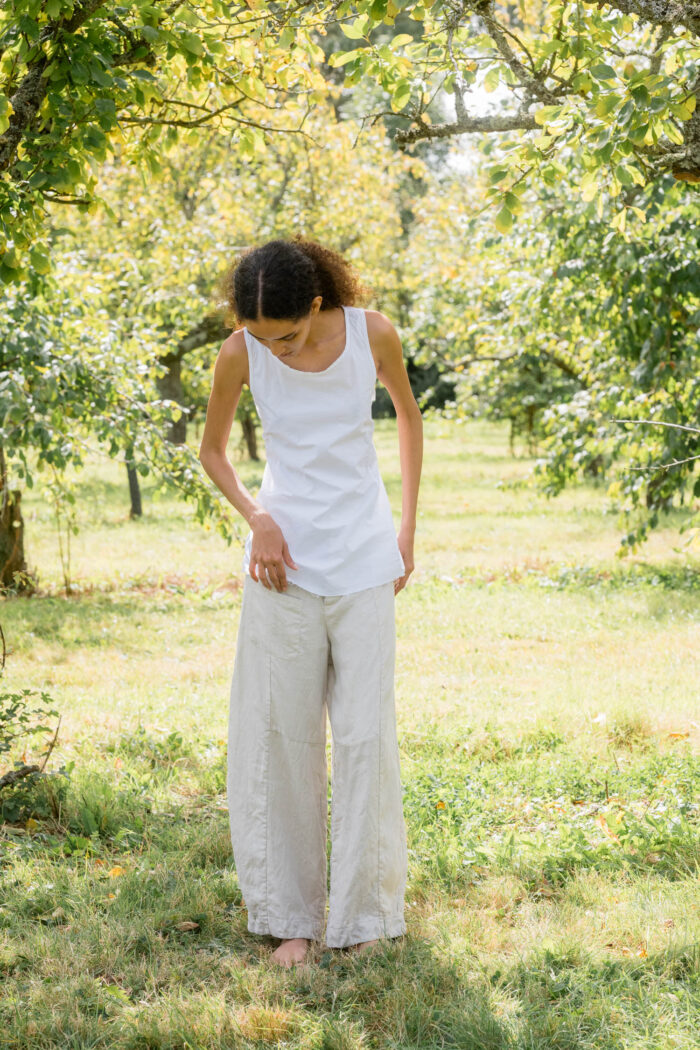 model wearing tailored line pants sula linen barrel leg trousers and apron blouse