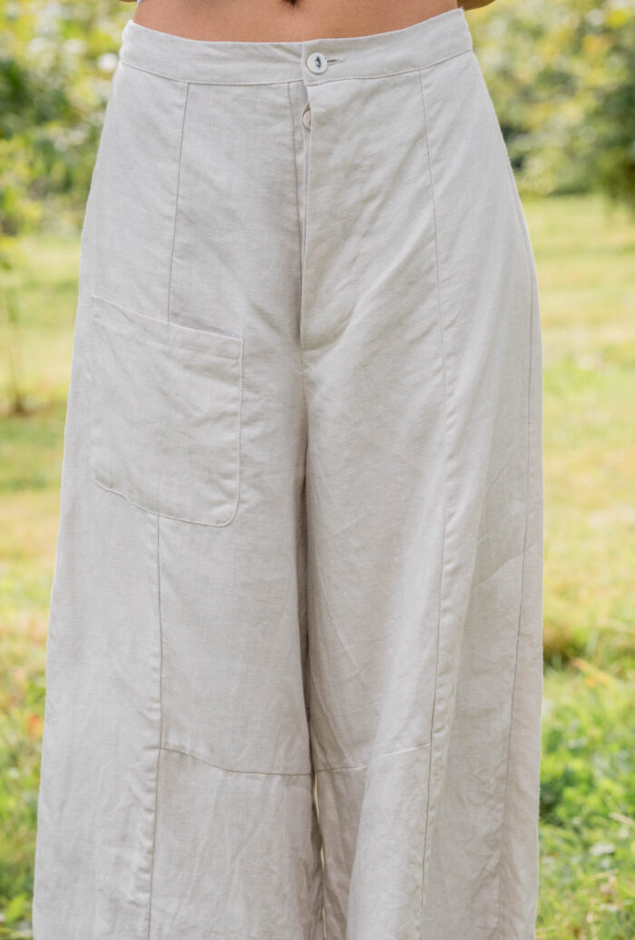 model wearing tailored line pants sula linen barrel leg trousers and apron blouse